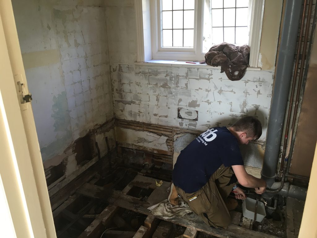 DSB Ltd plumber removing water from the pipes in a bathroom remodel in Teignmouth